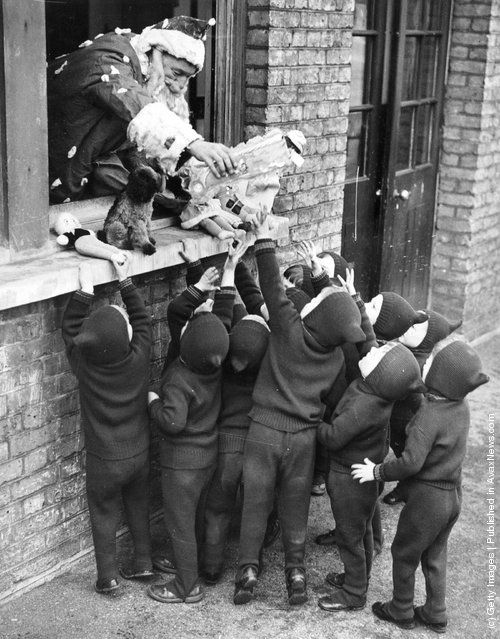 1938: Father Christmas hands out presents to children at the Aid And Adoption Society home at Leytonstone